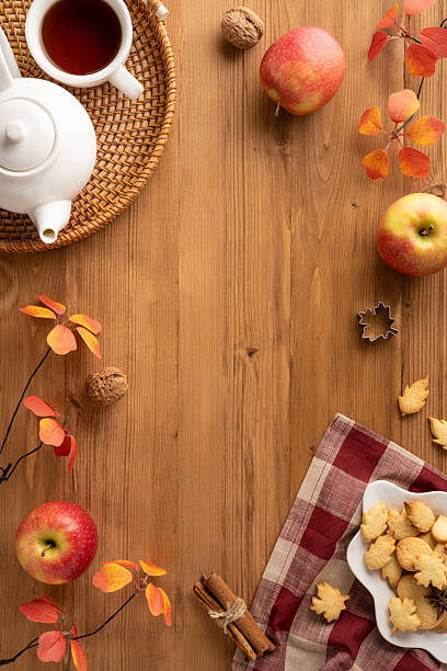 A cozy flat lay showcasing autumn elements, featuring warm-toned decor, tea, apples, cookies. Highlights a warm and inviting seasonal atmosphere, perfect for fall-inspired designs and content