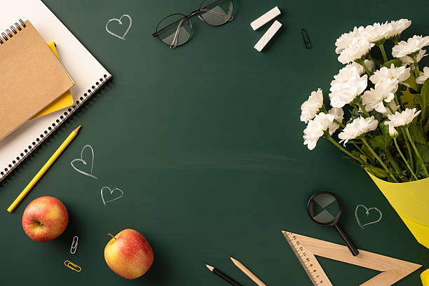 istock Celebratory desktop arrangement for Teachers' Day with educational items, apples, and white flowers 2230179571