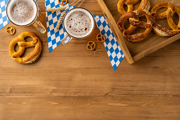 istock Beer Fest celebration featuring cold beer mugs, salted pretzels, and Bavarian flag patterns on flatlay overhead view wood 2230179589