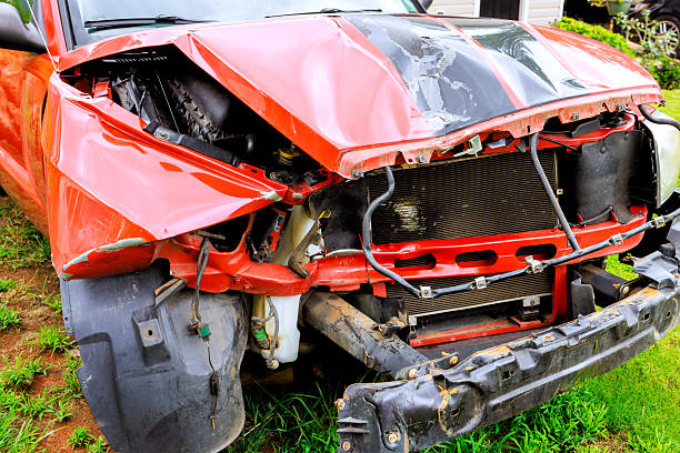 Scratches and dents mark the side of a white vehicle near the wheel.