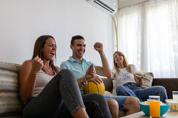 istock Friends watching basketball game at home 2230196576