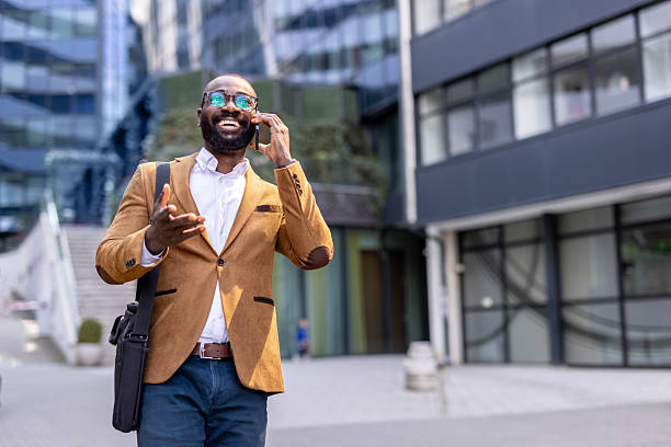 istock Businessman walking and talking on phone in urban setting 2230204687