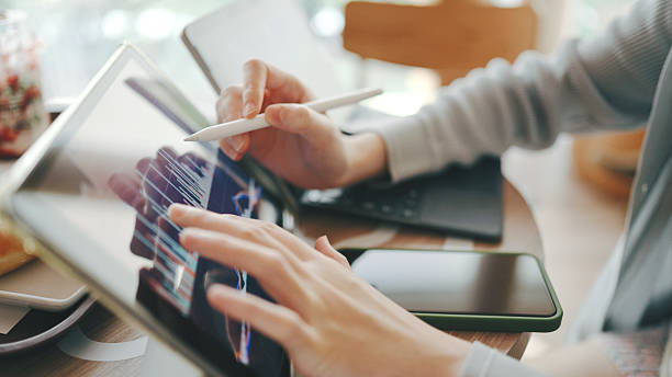 A Gen Z woman focuses on a tablet while sitting in the park, symbolizing flexibility in learning and working.  remote work, online class, digital workspace, tablet use, tech-savvy student, greenery, education tech.