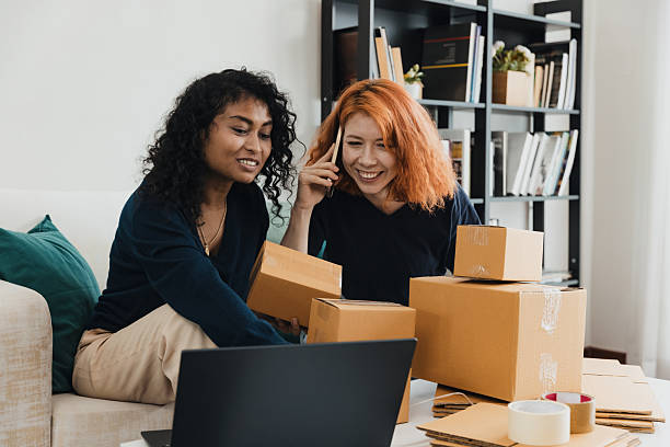 istock Two friends collaborating on a project with packages and a laptop in a cozy indoor setting during daytime 2230205390