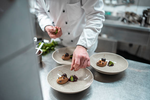 istock Chef Plating Gourmet Dishes in a Professional Kitchen with Elegant Presentation 2230205543