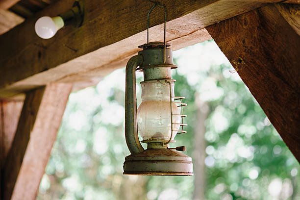 istock Rustic old lantern hanging from wooden rafters in the afternoon 2230206289