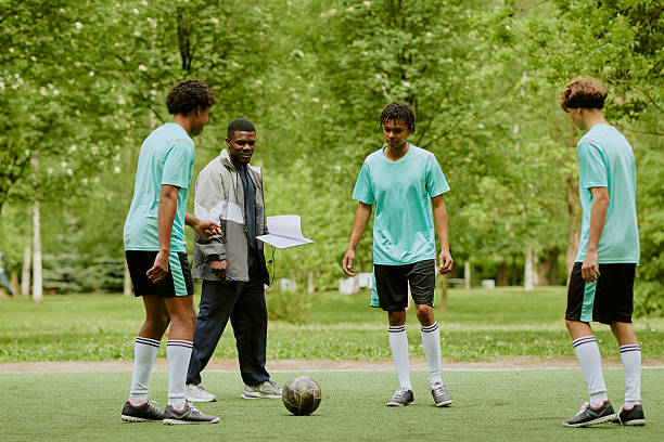 istock Multiethnic Teen Boys Practicing Soccer Outdoors with Coach Giving Instructions 2230206474
