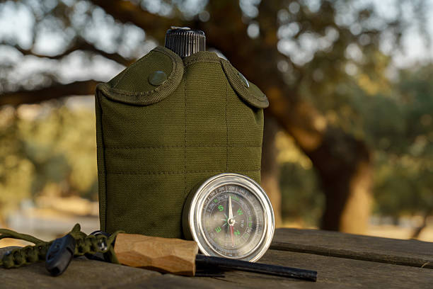 istock Canteen, compass, fire starter and whistle resting on wooden table in nature 2230212066