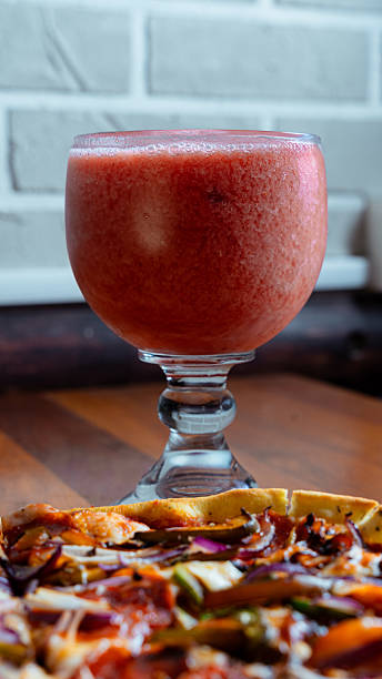 Strawberry smoothie complements delicious vegetarian pizza on restaurant table