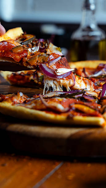 istock Hand taking a slice of delicious pizza with melted cheese 2230212568