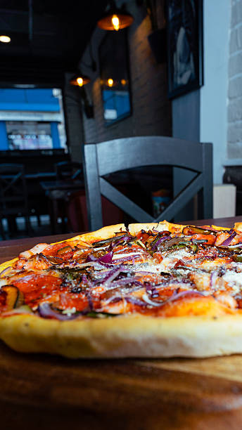 istock Delicious pizza resting on wooden board in restaurant 2230213044