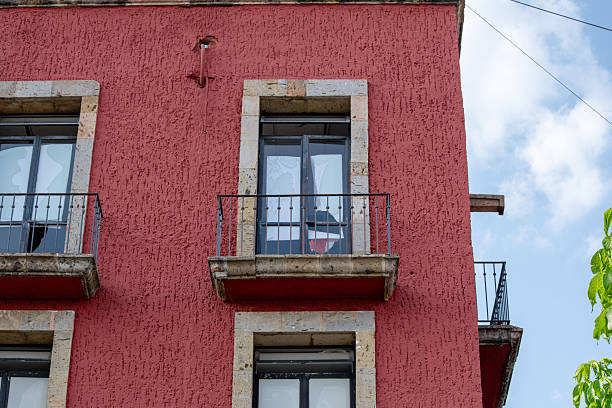istock Mexican flag displayed behind balcony window on red building in downtown Zapopan 2230220255