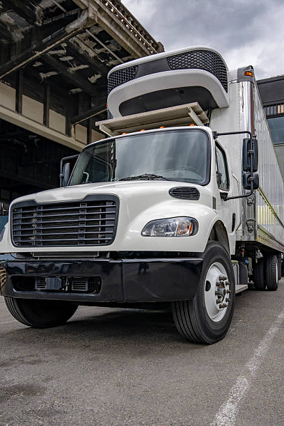 istock Compact day cab middle duty rig semi truck with refrigerated box trailer standing on the industrial parking lot 2230222484