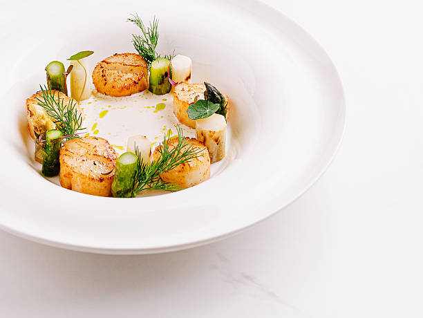 istock Seared scallops with herbs, served elegantly in a bowl 2230224479