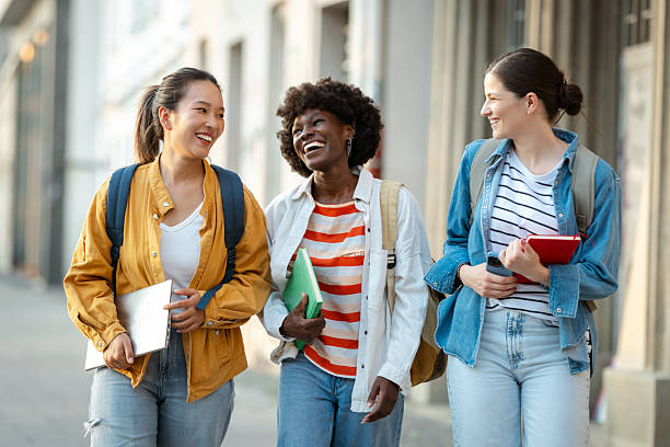 istock Group of diverse students walking outdoors carrying books and smiling 2230227580