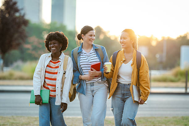 istock Three female students walking outdoors smiling and chatting during a sunny afternoon 2230227581