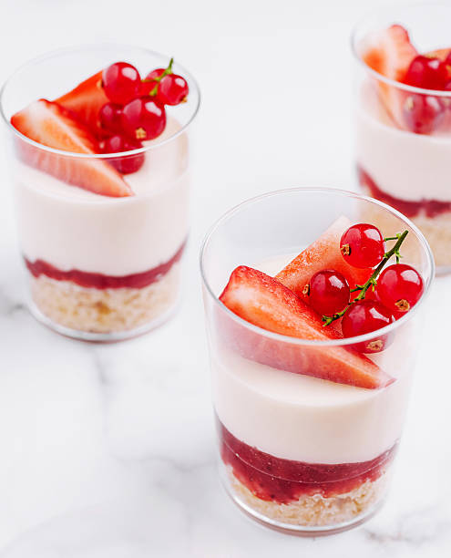 istock Delicious dessert cups with strawberries and redcurrants on a marble table 2230230678