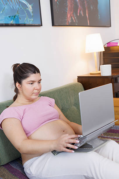 istock Pregnant young woman working at home, using laptop 2230230970