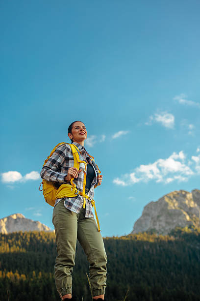 istock Female hiker standing with the blue sky behind her 2230231984