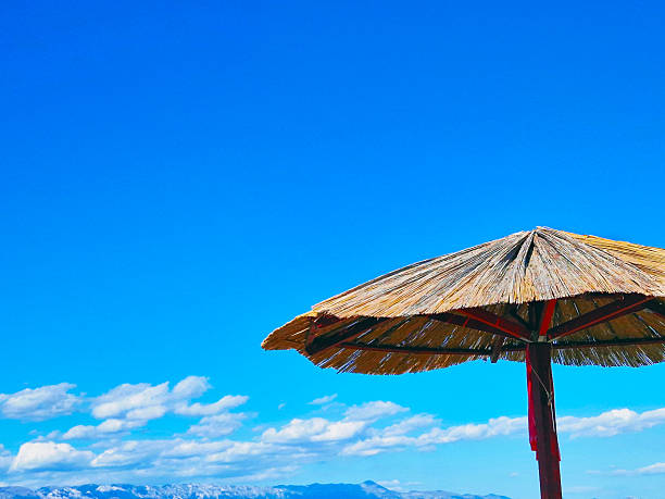 Red beach umbrellas with blue sea and sky.