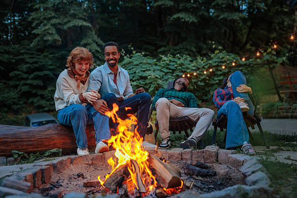 istock Two couples enjoying a lazy evening next to a campfire 2230237228