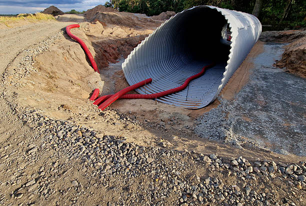 istock A corrugated iron tunnel will serve as a bridge over a stream under the road. Instant quick solution made of metal screwed pipe from parts. Bomb and missile shelter for civilians is being built 2230238272