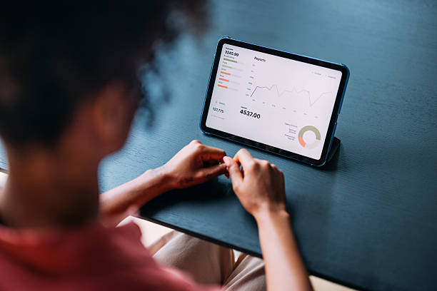istock Person Examining Digital Financial Report on a Tablet in a Modern Setting 2230239882