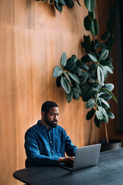 istock Man Working on Laptop in Modern Office with Stylish Interior Design 2230239894
