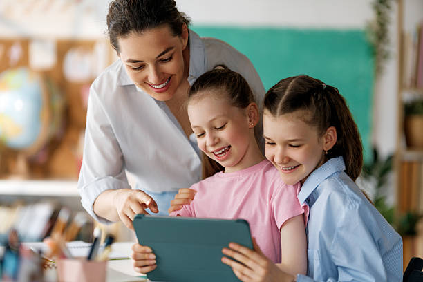 istock Happy kids and teacher at school 2230243398