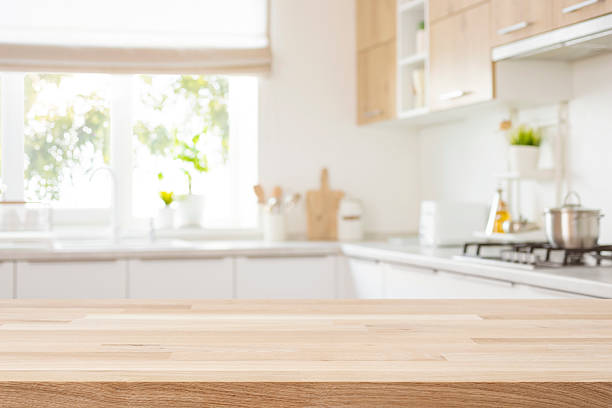 istock Empty wooden table with bright interior of kitchen as blurred background behind 2230245324