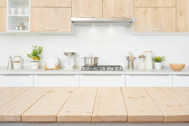 istock Table top from wooden planks with blurred modern kitchen interior as background behind 2230245348