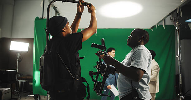 istock Help, equipment and men with camera on set for adjustment, stabilizing tech and filming. Behind the scenes, videography and person with operator for shooting, production and filmmaking in studio 2230248666
