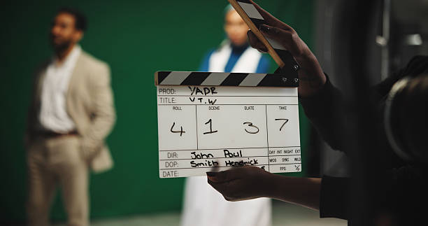 istock Person, producer and hands with clapperboard on set for take, action or camera roll in production. Closeup, director or assistant with movie slate for film making, videography edit or start scene 2230248680
