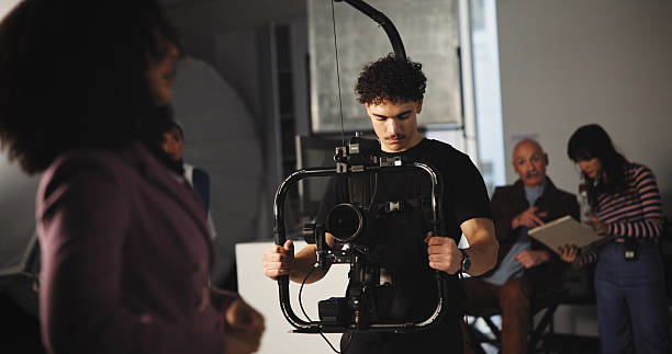 istock Man, cameraman and stabilizer with journalist on set of broadcast, production process and record. People, tech and cinematographer for shooting news, documentary footage and rehearsal for commercial 2230248705