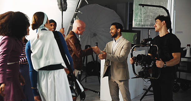 istock Handshake, teamwork and director in studio for creative production, filmmaking and shooting success. Behind the scenes, tech and cast with crew celebrate for videography, process and thank you on set 2230248715