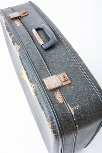 istock Vintage black suitcase with worn edges and a weathered surface, showcasing a classic travel accessory with a nostalgic appeal for adventure and exploration 2230248966