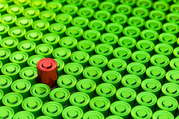 One Red Battery Cell Standing Out Among Green Lithium-Ion Batteries