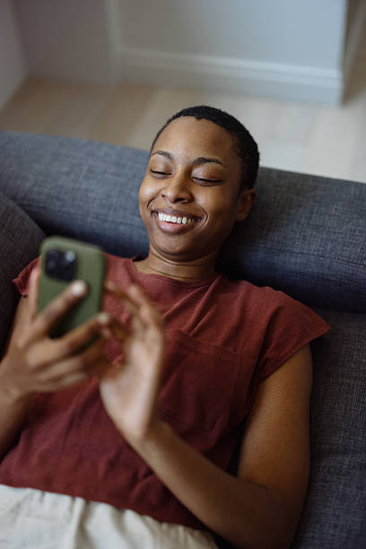 istock Young woman relaxing on the sofa using her smartphone 2230251517