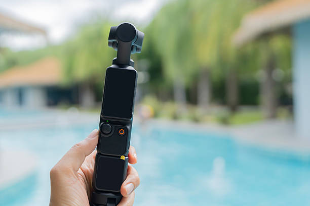istock Action camera with three-axis suspension on woman hand over swimming pool 2230253002