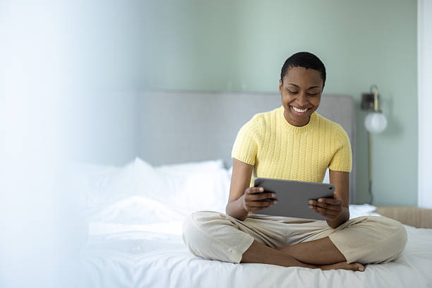 istock Young woman using digital tablet in bed smiling 2230263003