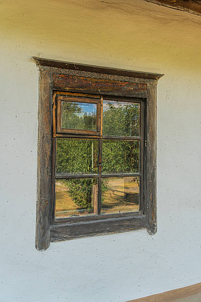 istock Stone or plaster wall with aged window, diamond pane pattern, lush garden, soft lighting, off-center perspective, naturalistic style, tranquil, traditional rural architecture 2230264663