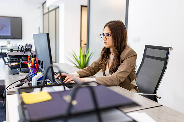 istock Professional woman in glasses working at computer desk 2230269724