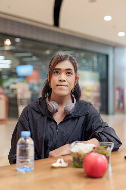 istock Transgender non binary woman eating healthy salad in restaurant while confidently looking at camera 2230270407