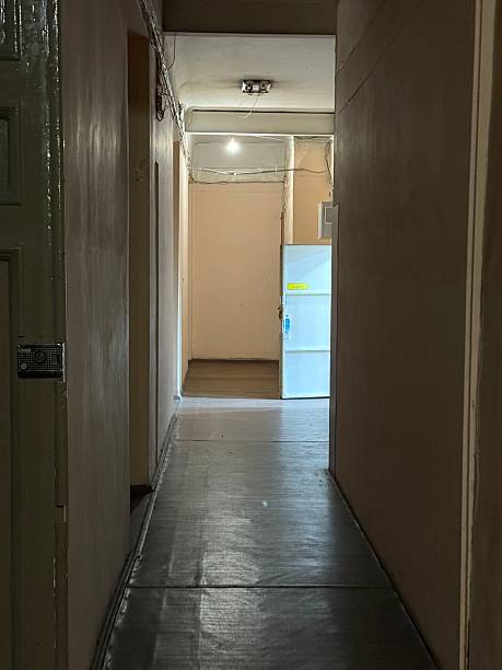 istock Dimly Lit Narrow Hallway with Light at the End 2230273069