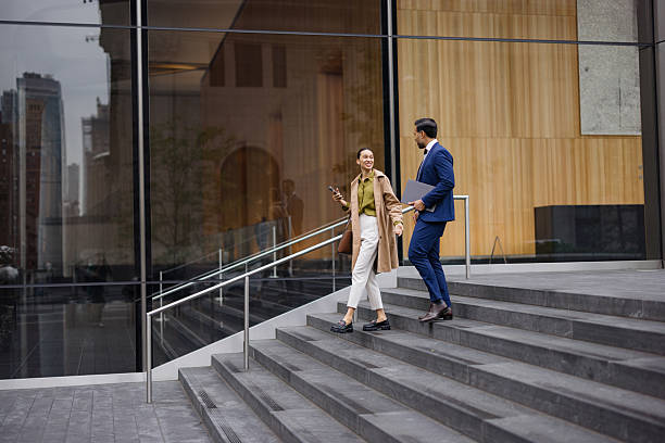 istock Businesspeople walking down the stairs and talking 2230273650