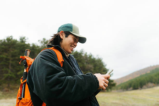 istock Asian man using mobile phone to plan a hiking route 2230276995