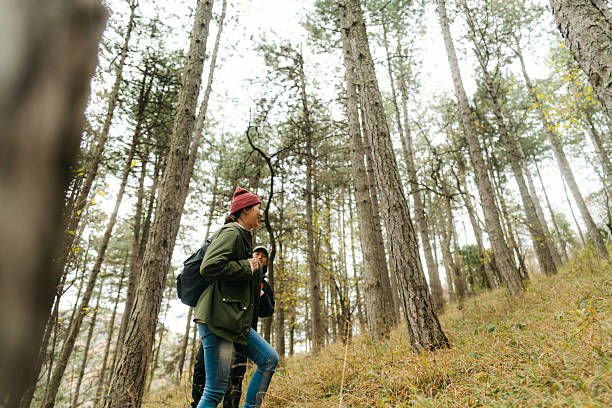 Photo of a smiling Asian couple on a hiking adventure, on a gloomy, autumn day