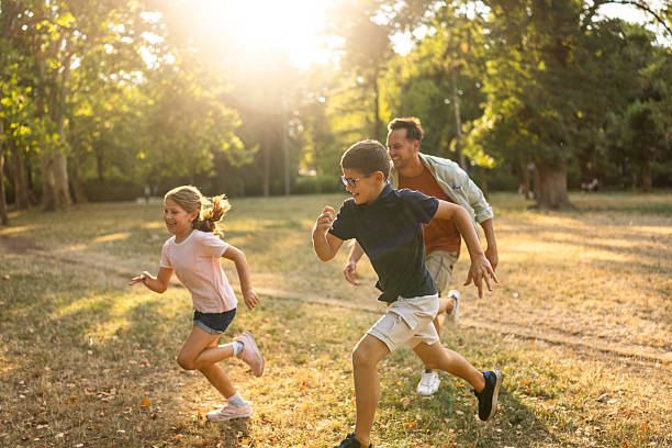 istock Family Playing Together Outdoors in Nature During a Bright Sunny Day 2230278021
