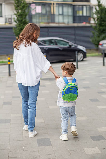istock Mother walking son to school with backpack. 2230279160
