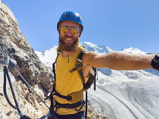 istock Smiling Male Climber Taking Selfie on Mountain 2230279539